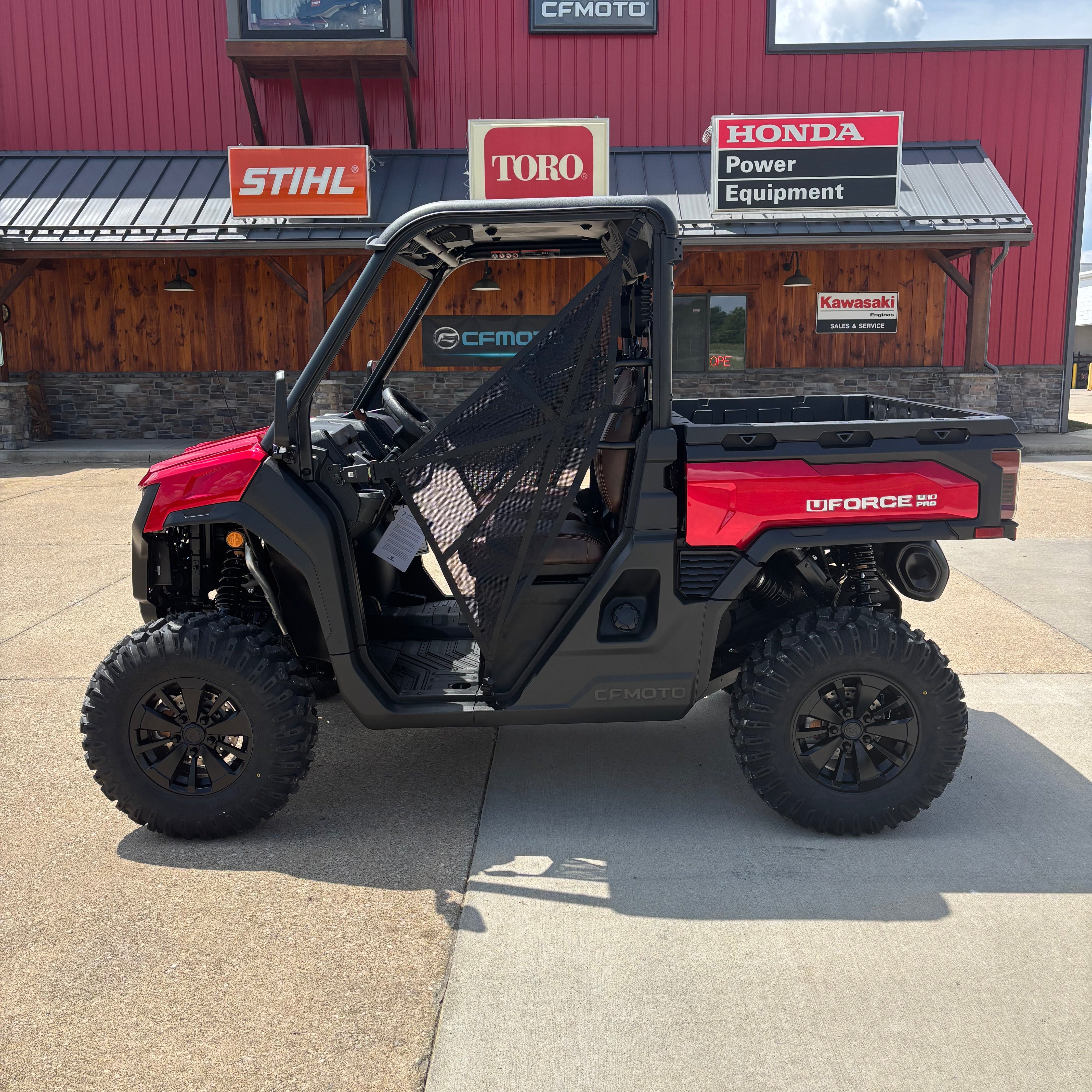 Red Cfmoto U10 pro side view sitting in parking lot. Stock tires