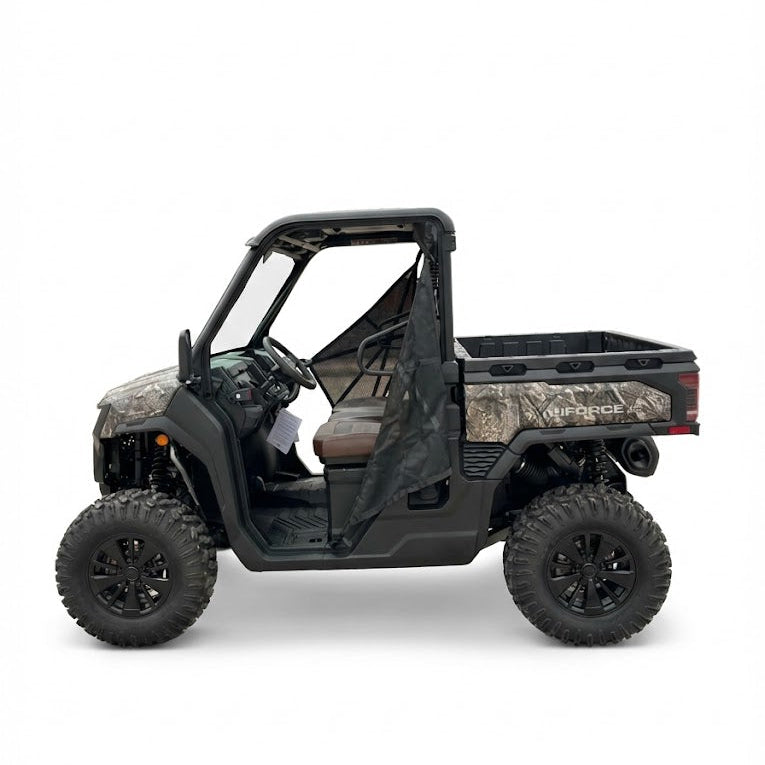 Side view of a black and camouflage utility side by side on a white background