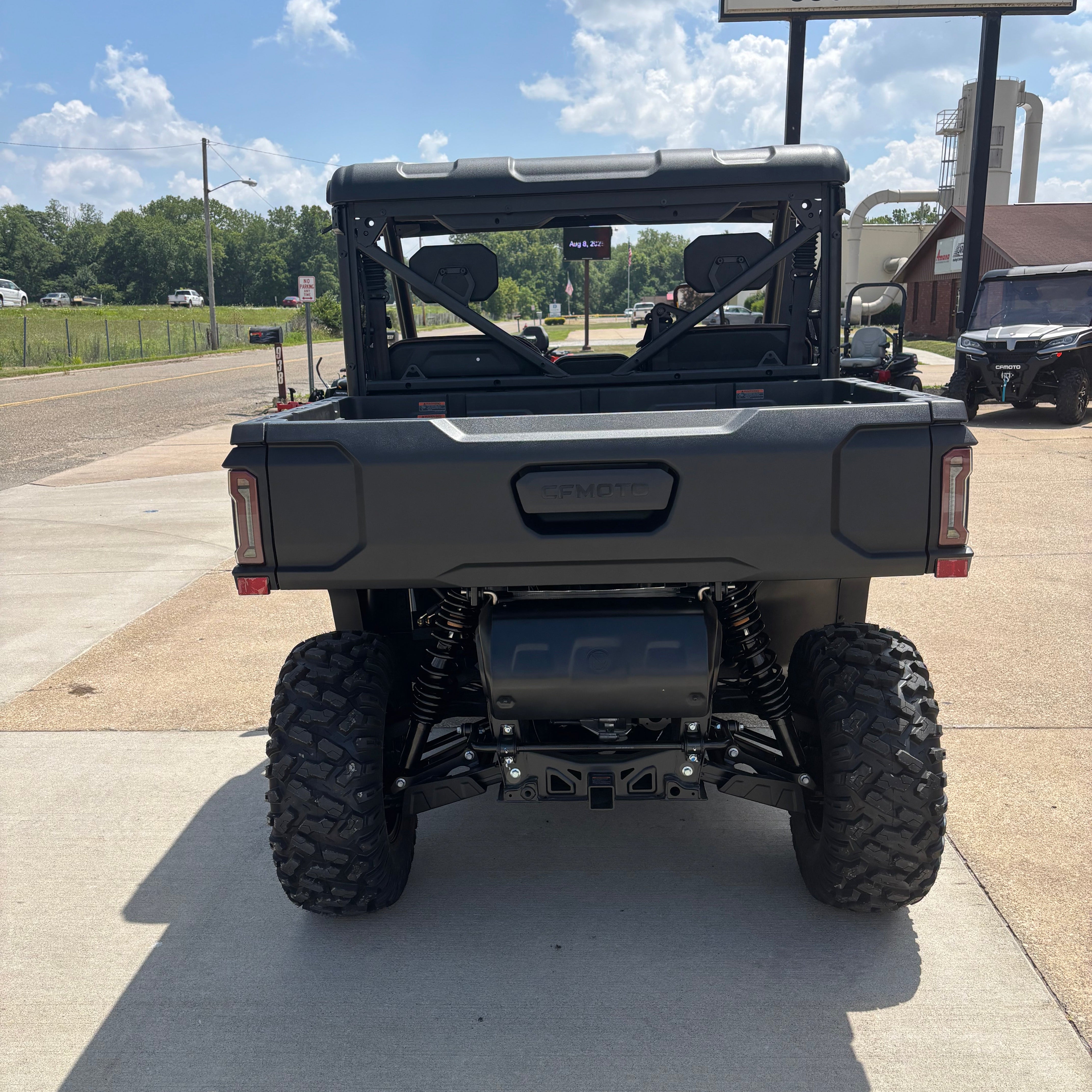 Black off-road vehicle on a paved road with a clear sky