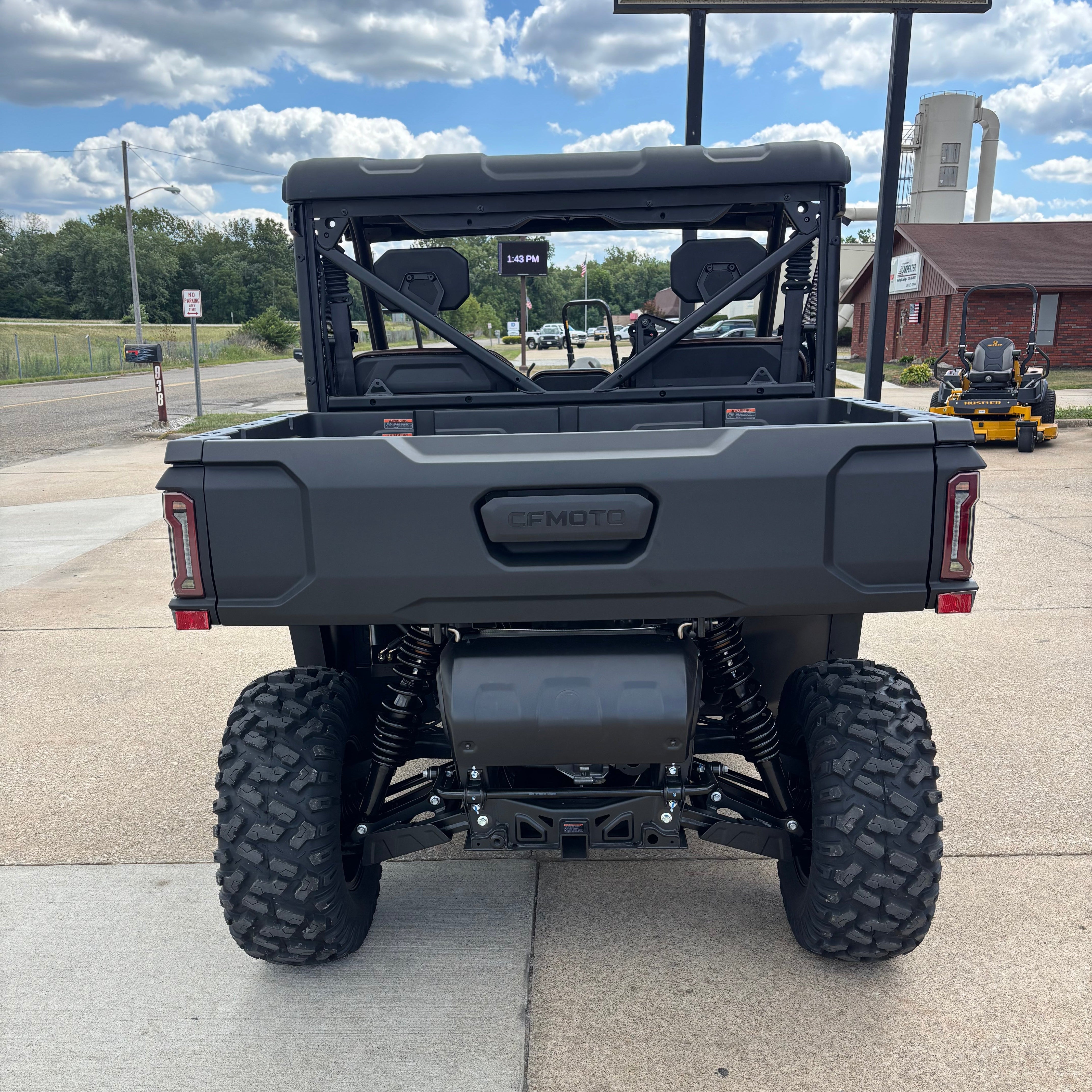 Black off-road vehicle on a concrete surface with a cloudy sky in the background.